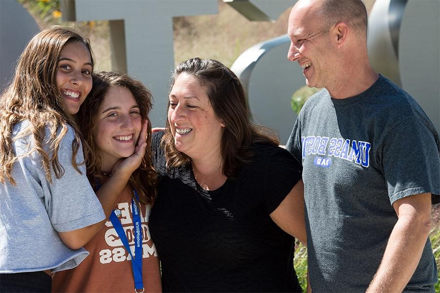 parents embrace enrolled UMass Boston Student on Move In Day